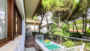 A balcony with a table, chairs, and a fruit bowl. - Quiet Flat With Garden (Lignano Sabbiadoro)