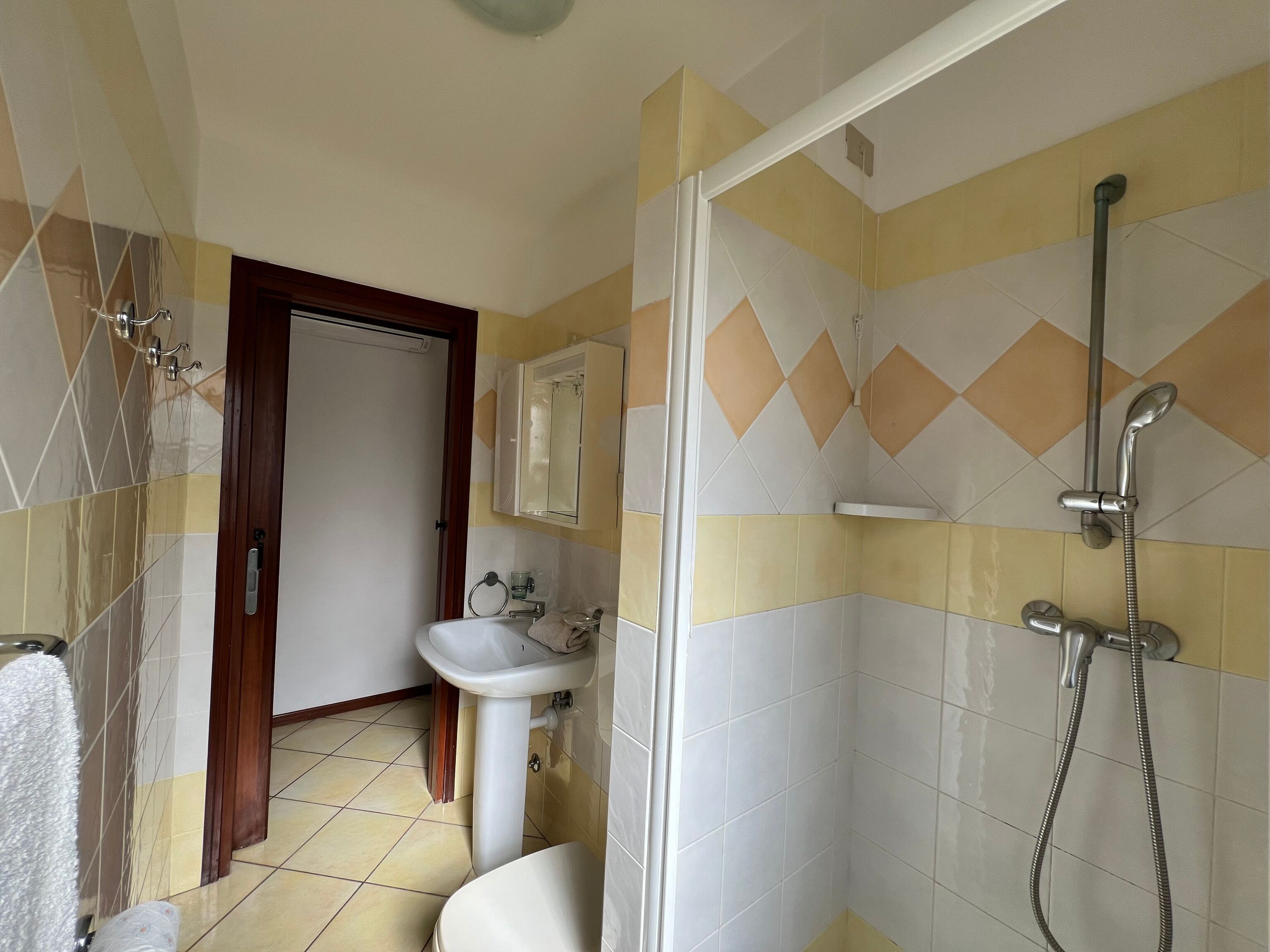 A bathroom with a shower, sink, and toilet.