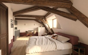 A bedroom with a sloped ceiling, a bed, a desk, and a chair. - Malerweg Residenz (Pirna)