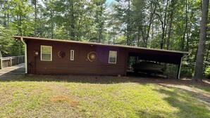 A cabin with a covered porch, a small window, and a door. - Soothing 2-bedroom cabin with AC in charming Bassett (Bassett)