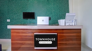 A reception desk with a sign indicating 'TOWNHOUSE Company-Serviced.'