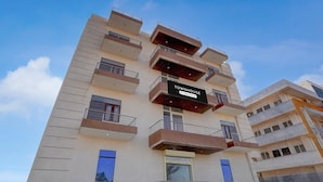 A multi-story building with balconies, a sign reading 'Townhouse,' and a gated entrance.