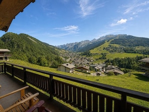Ein Balkon mit Blick auf ein Dorf und Berge.