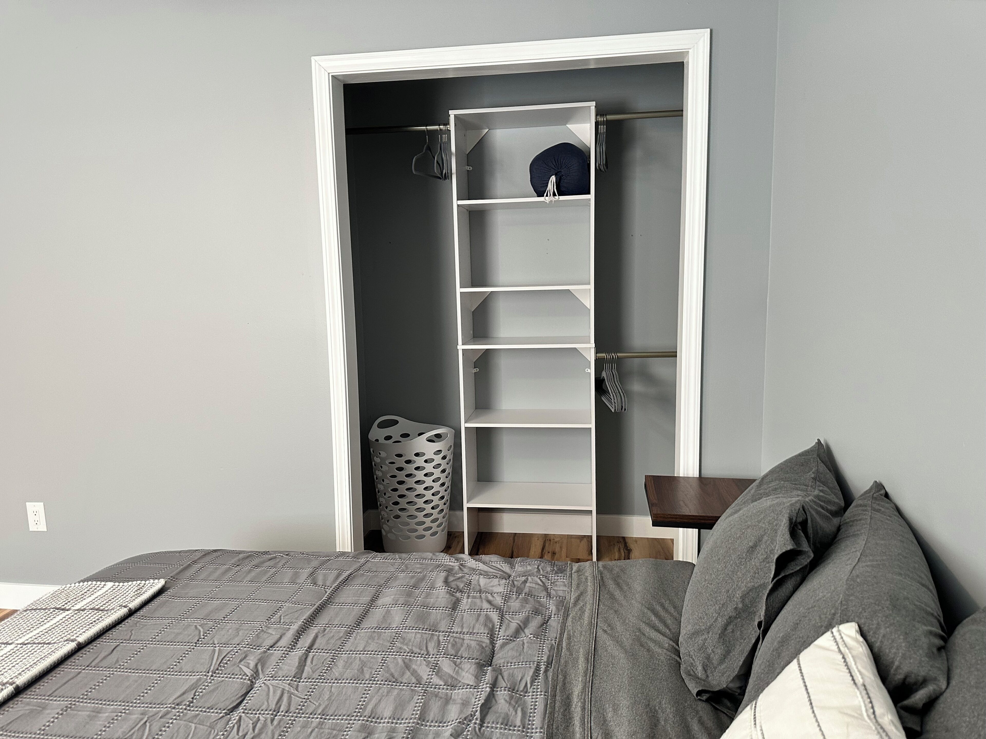 Une chambre à coucher avec un lit, une armoire et une petite table.