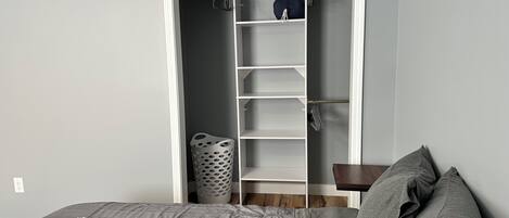 Une chambre à coucher avec un lit, une armoire et une petite table.