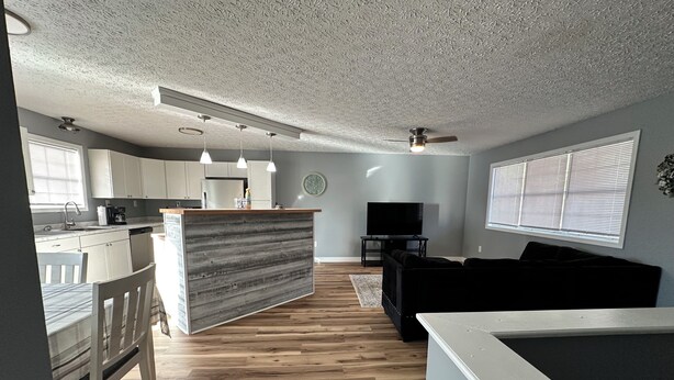 Un espacio habitable moderno con cocina, comedor y zona de estar con televisor.