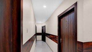 A hallway with wooden doors and white walls.