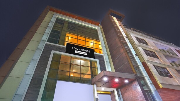 A modern building with a sign reading 'TOWNHOUSE' and a company-serviced logo.