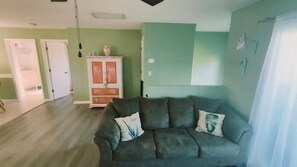 A living room with a sofa, a cabinet, and a door.