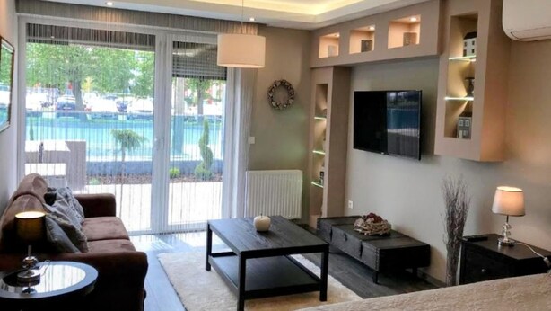 A modern living room with a sofa, coffee table, and TV.