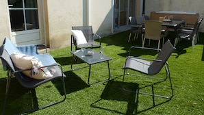 An outdoor patio with chairs, a table, and a small decorative item on the grass. - Charming house 3 suites/terrace/garden 6 persons (Moulins)