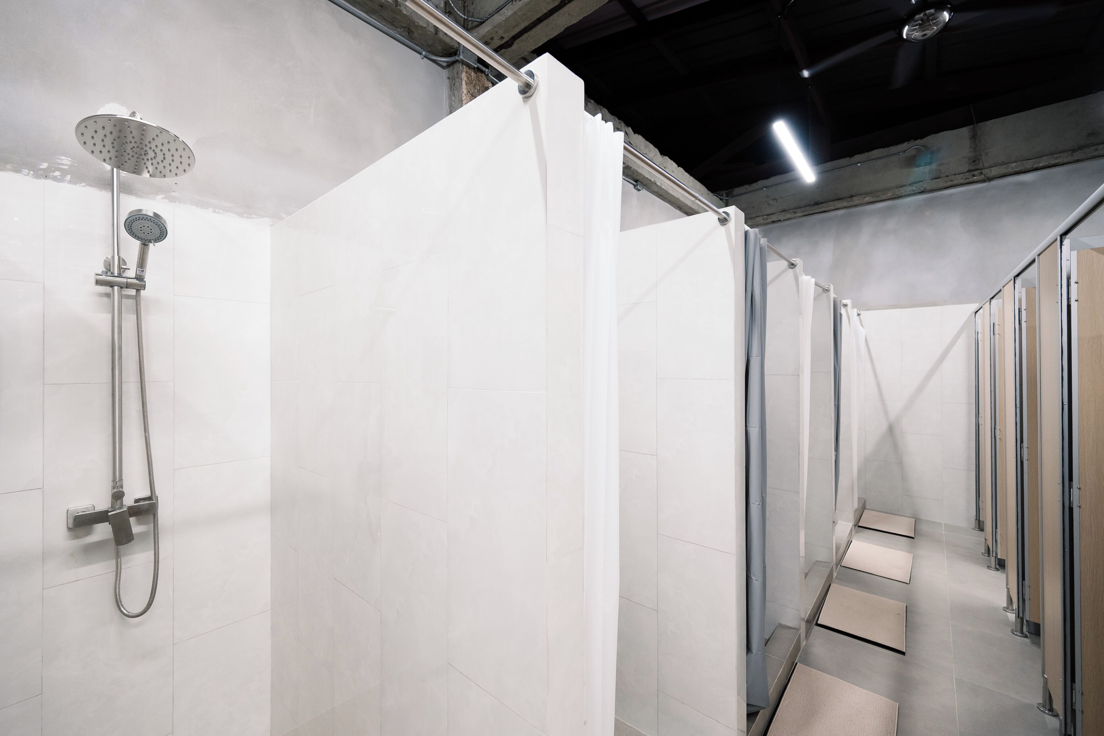 Un baño moderno con ducha, paredes de azulejos y techo de metal.
