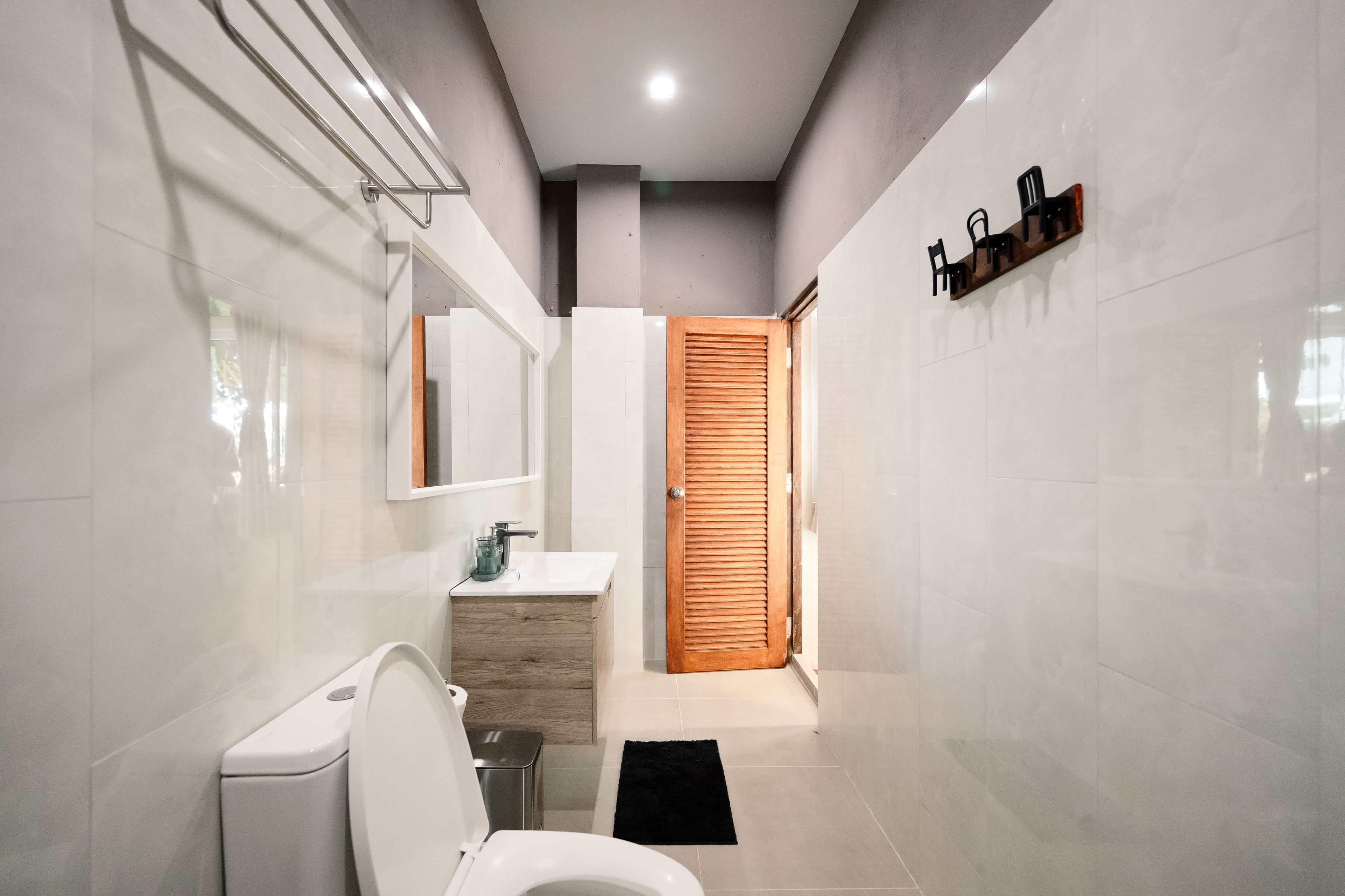 A modern bathroom with a toilet, sink, and mirror.