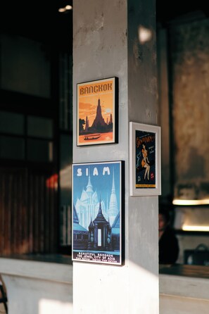 A wall with three framed posters advertising Bangkok, Siam, and a book cover. - Kosin House (Bangkok)