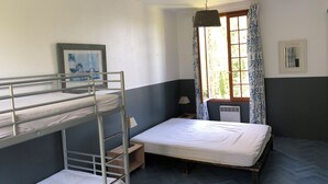 A bunk bed room with a window, a radiator, and a lamp. - Gîte le Moulin Fontaine (Saint-Martin-le-Gaillard)