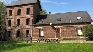 A two-story brick building with a picnic table in front. - Gîte le Moulin Fontaine (Saint-Martin-le-Gaillard)