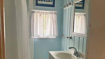 Regadera, secadora de cabello, papel de baño