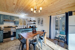 Eine Küche mit Holzboden, blauen Schränken, einem Holztisch und einem Kühlschrank.