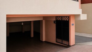 Entrada de un edificio con una puerta cerrada y un letrero que indica zona de estacionamiento.