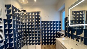 Un baño moderno con ducha, lavamanos y bañera.