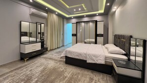 A modern bedroom with a large bed, a bedside table, a wardrobe, and a mirror. - ELITE Comfort 3BR Apartment New Cairo   (New Cairo)