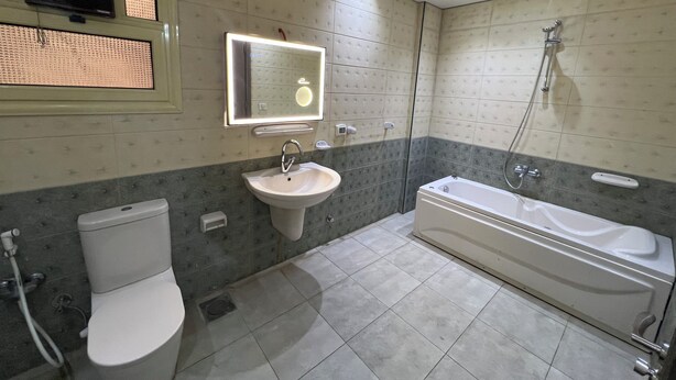 A bathroom with a toilet, sink, and bathtub. - ELITE Comfort 3BR Apartment New Cairo   (New Cairo)