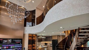 A spacious interior with a modern staircase, a flat-screen TV, and a dining area. - Duplex Penthouse - River Bridge View in City Center, Thu Thiem, Ho Chi Minh City (Thành phố Hồ Chí Minh)