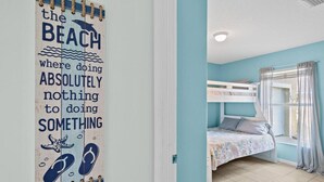 A room with a bunk bed, a window with curtains, and a wall with a poster. - Beach Retreat 3BR/2BA – Across Paradise Park, Melbourne FL (Melbourne)