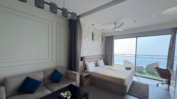 Une chambre d’hôtel moderne avec un lit, un canapé et un balcon offrant une vue agréable.