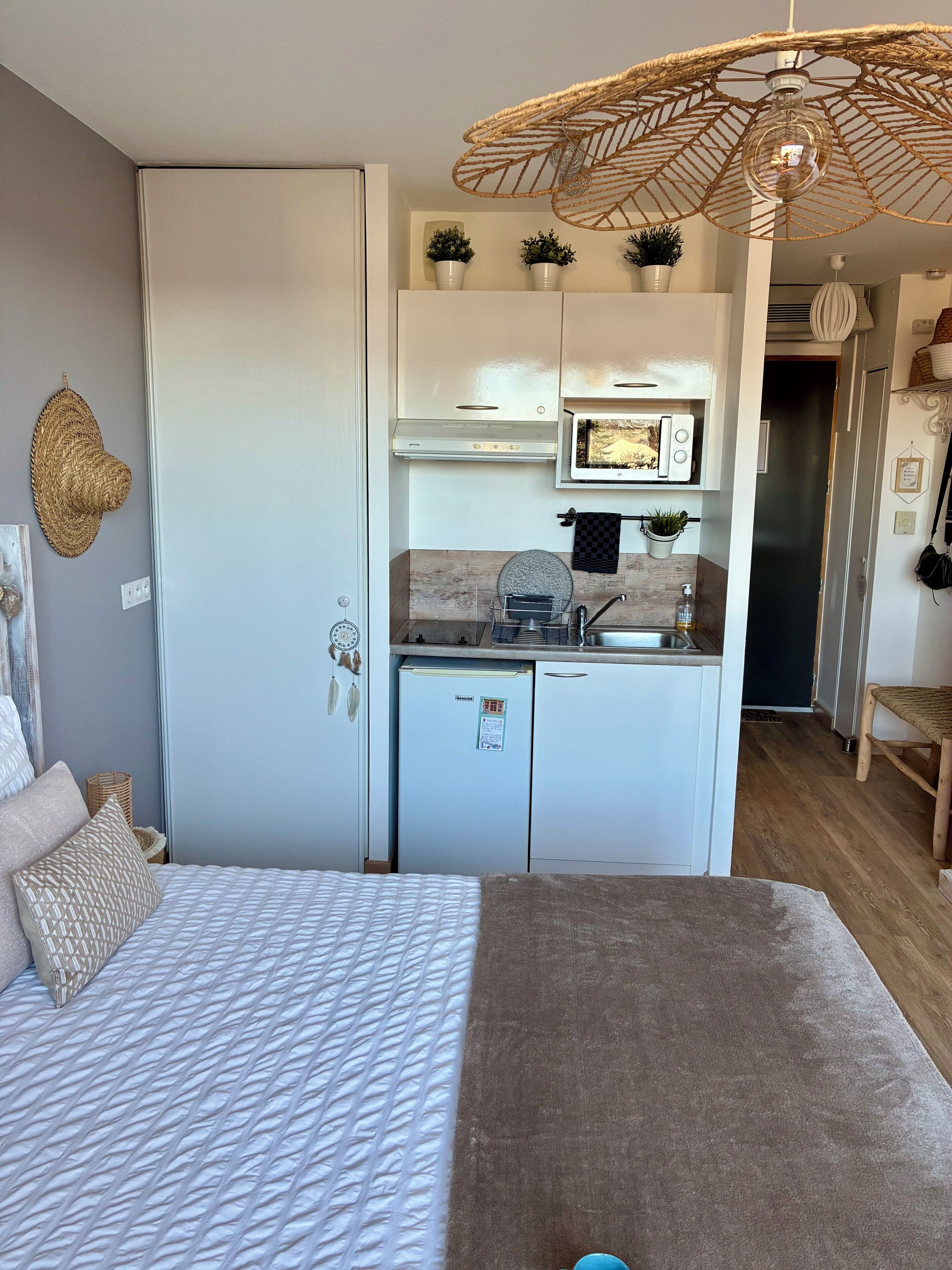 Ein kleines Zimmer mit Bett, Küchenzeile und Essbereich.