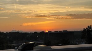 A sunset over a cityscape with buildings and a clear sky. - Lakes, Links, and Luxury at The Landing Overlook!  Private Balcony w/ Sunsets! (Branson)