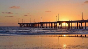A pier extending into the ocean at sunset with people walking along it. - The Sail & Sky Suite - Chic 2BR Elegance with Stunning Marina Panoramas (Marina del Rey)