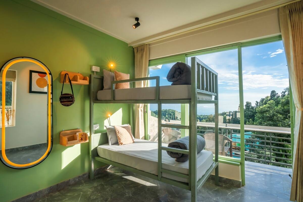 A bunk bed room with a view of a balcony and a pool.