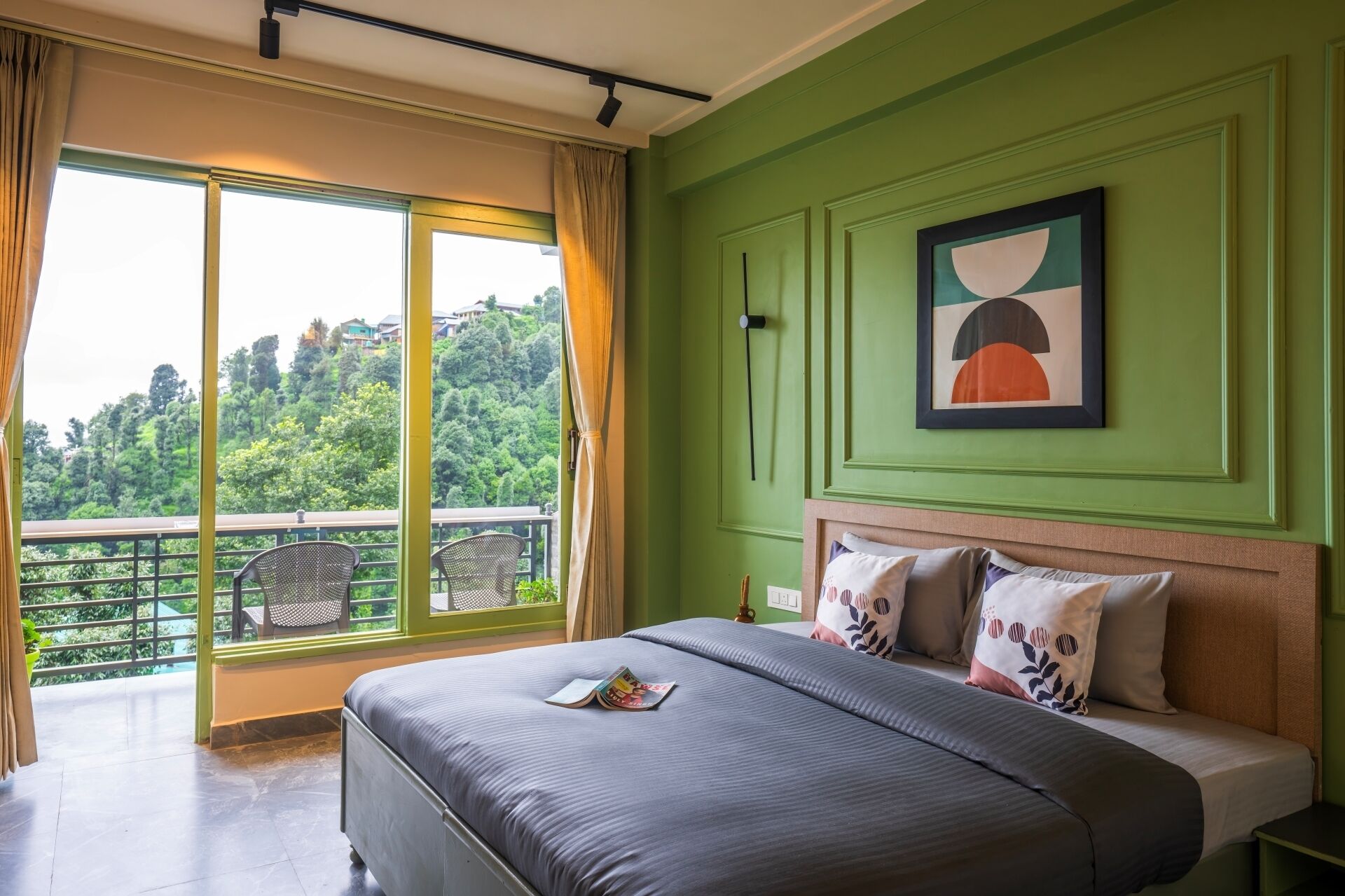 Un dormitorio con una cama grande, vista a un balcón y una pared verde.