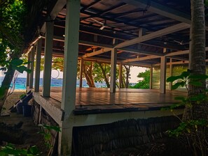 An open-air pavilion with a wooden deck, surrounded by trees and overlooking a body of water. - Silver Bay Kamadhoo (Kamadhoo)