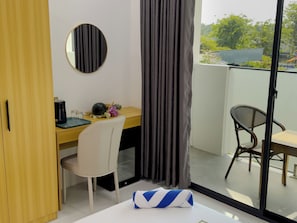 A room with a wooden desk, a chair, a small table, a round mirror, and a window with curtains. - Silver Bay Kamadhoo (Kamadhoo)
