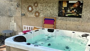 Un jacuzzi con revestimiento de madera, techo de baldosas y un cuadro colgado en la pared.