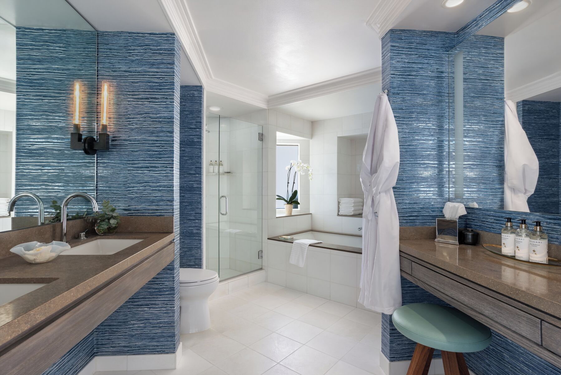 A modern bathroom with a glass shower, a vanity with a mirror, and a bathtub.