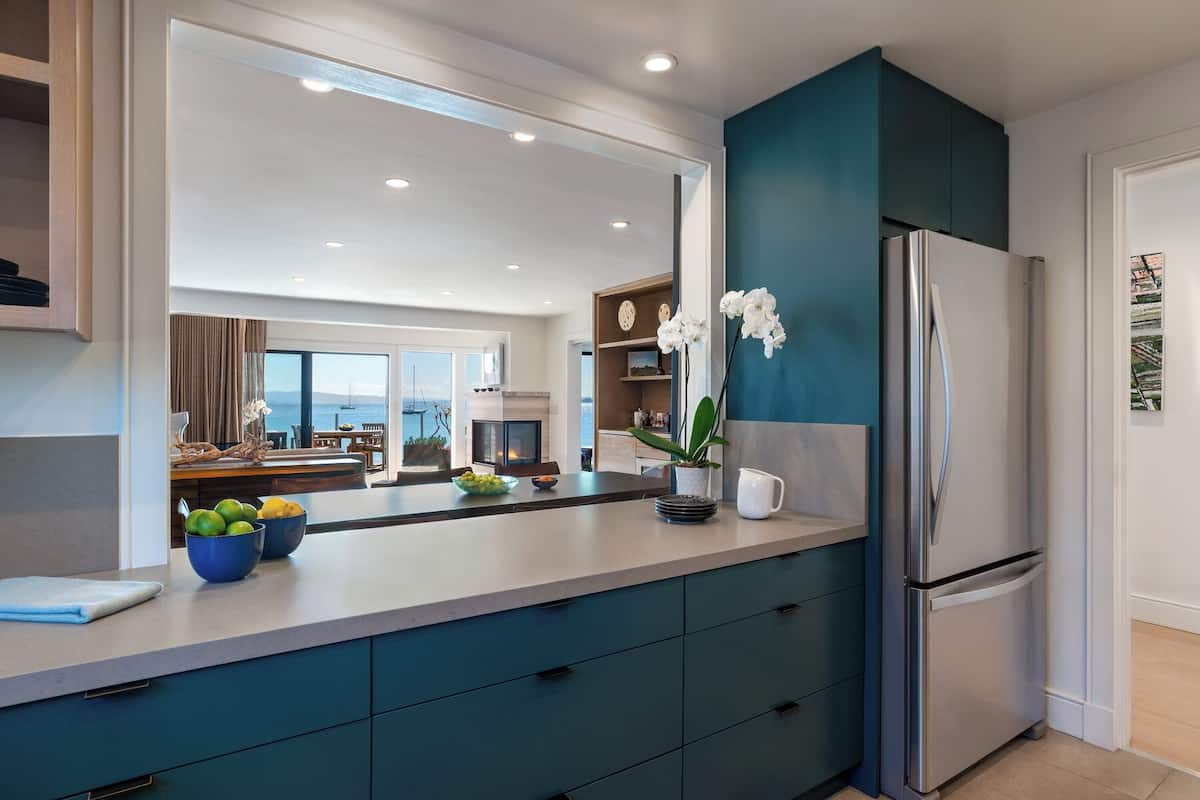 Una cocina moderna con una isla grande, un refrigerador y vistas al mar.