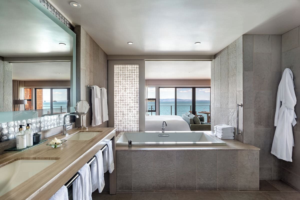 Un baño moderno con una bañera grande, una zona de ducha separada y un tocador con espejo.