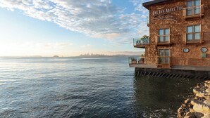 Un edificio sul lungomare chiamato 'The Inn Above Tide', con vista sull'acqua e sullo skyline della città.