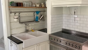 Una cocina con armarios blancos, una estufa de acero inoxidable y un lavamanos.