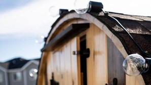 Una estructura de madera con una puerta, un símbolo de cruz y un símbolo de luna creciente.