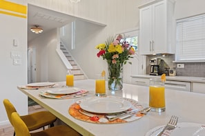 Una cocina con espacio para desayunar, que incluye platos, cubiertos y vasos de zumo de naranja.