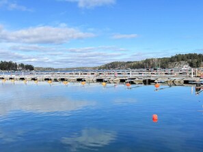 Ein Yachthafen mit mehreren Stegen und Booten, ruhigem Wasser und blauem Himmel.