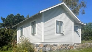 A single-story house with a stone foundation, white siding, and two windows. - 3 Person Holiday Home in Dalaro (Dalaro)