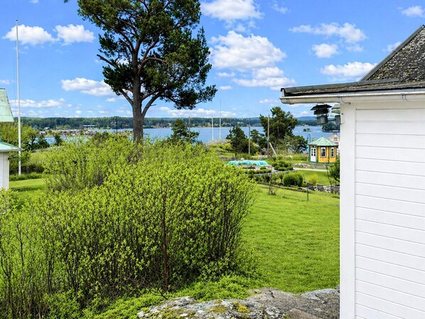 A residential area with a large tree, a swimming pool, and a view of a lake. - 3 Person Holiday Home in Dalaro (Dalaro)
