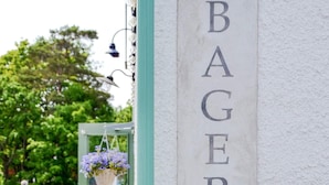 A building with a vertical sign reading 'BAGERI' and a door with a hanging flower basket. - 3 Person Holiday Home in Dalaro (Dalaro)