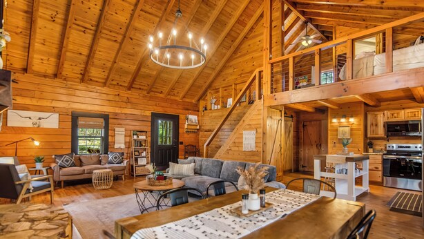 L’intérieur d’une cabane en bois comprend un coin repas, une cuisine et une chambre à coucher située en mezzanine.