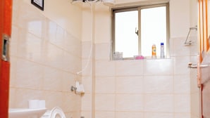 Un baño con inodoro, ventana y ducha.